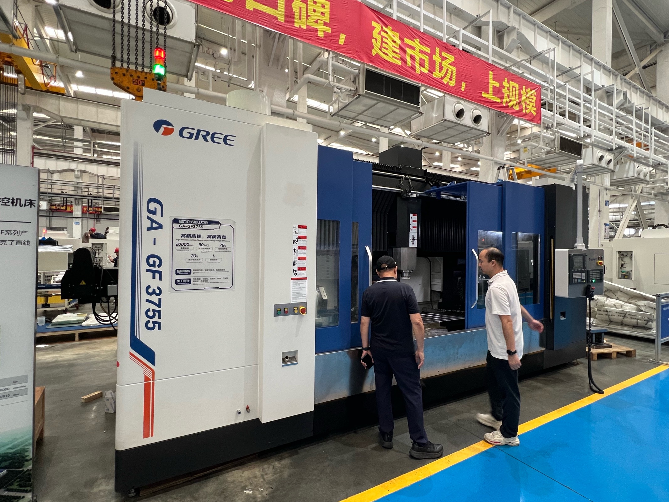 GA-GF3755 factory nameplate showing 20,000 rpm spindle, 70 m/min rapid, 30 m/min feed, 7.5 m/s² acceleration, 20-tool ATC, 5-year warranty — with Gree engineers on factory floor